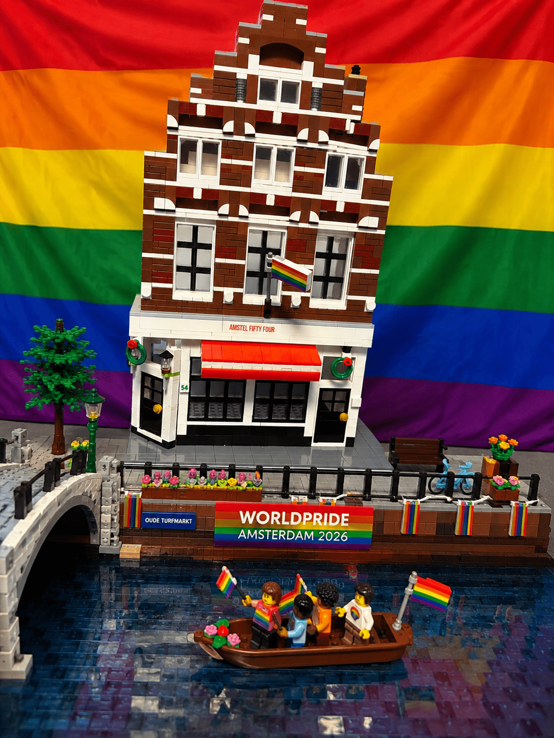 Afbeelding Amstel 54 met vlag regenboog. met mooie achtergrond regenboog vlag en gracht met boten die rond varen